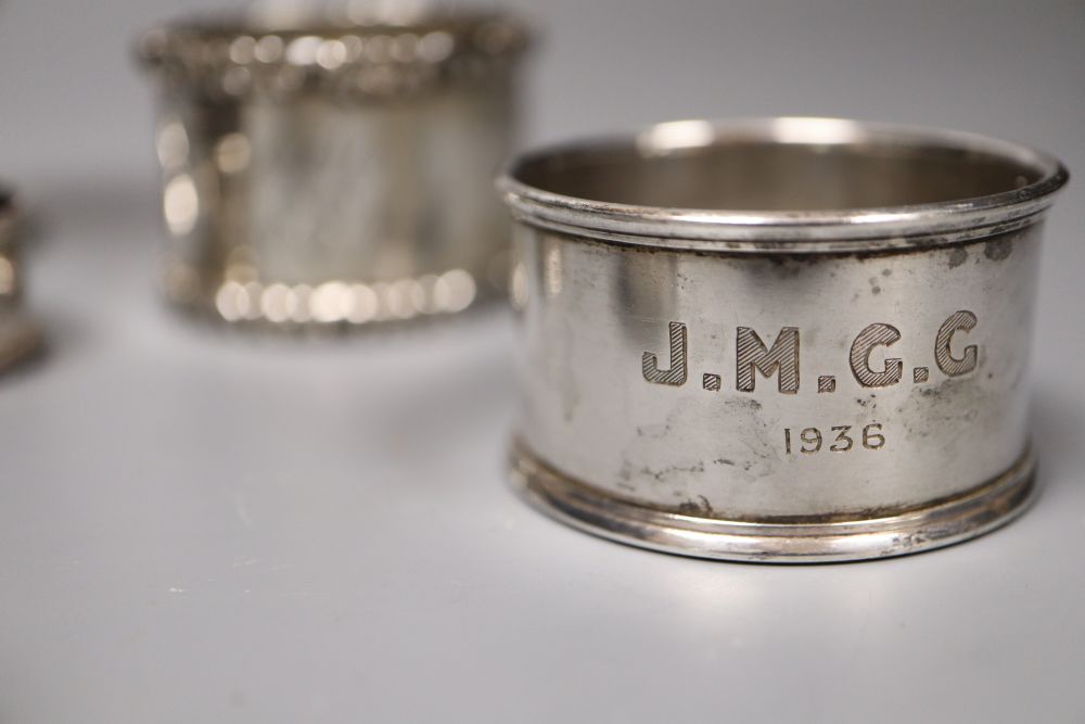 A pair of silver napkin rings, four other silver napkin rings and a small plated trophy cup.